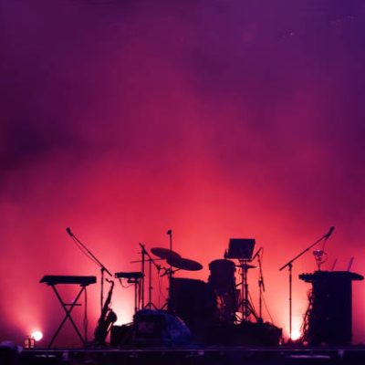 concert stage on rock festival, music instruments silhouettes, colorful background with copy space